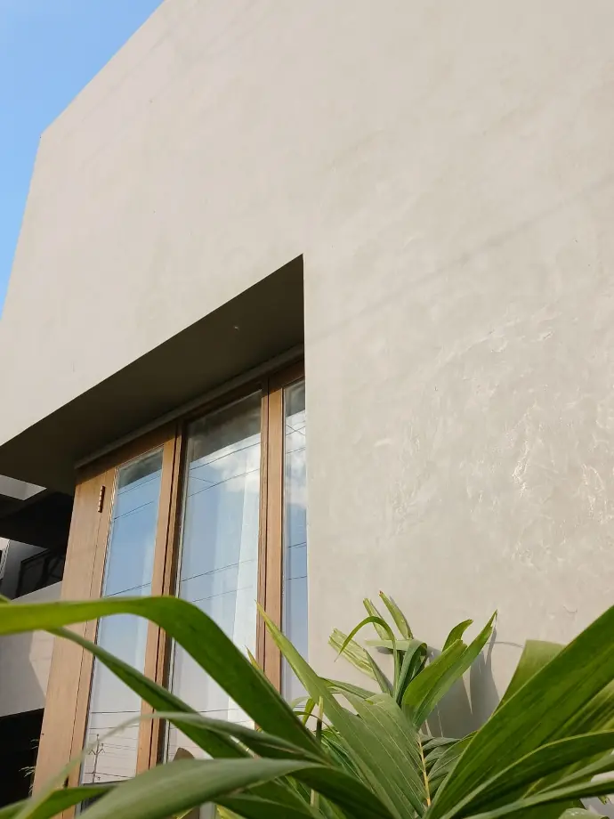 CemPlast with wood Exterior surface of a home coated with CemPlast, with a beautiful contast of polished natural wood frames.