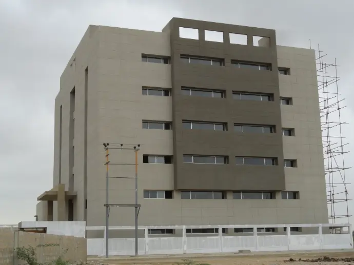 A beautiful cubicial shape building where CemTrox is applied in fairface concrete color.  Two large facade masses are coated in charcoal grey accents. 