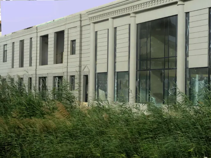 A large stretch facade wall of a mall. Fairface concrete colors is applied over classic roman style architecture